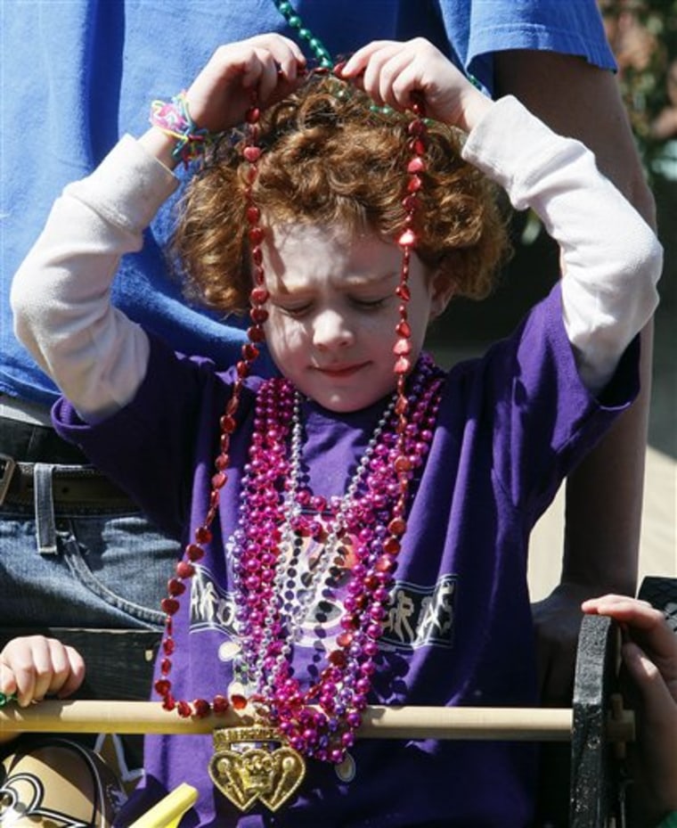 A young reveler dons a set of beads that she caught during the Krewe of Mid-City Mardi Gras parade on St. Charles Avenue in New Orleans, Sunday, March 6, 2011. Mardi Gras season ends with an all-day celebration on Tuesday, March 8th. (AP Photo/Patrick Semansky)